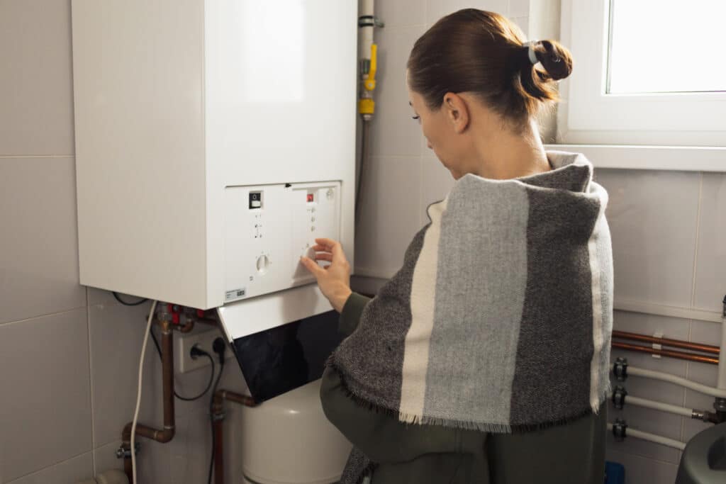 A woman reduces the power of the gas boiler in her home due to an energy crisis